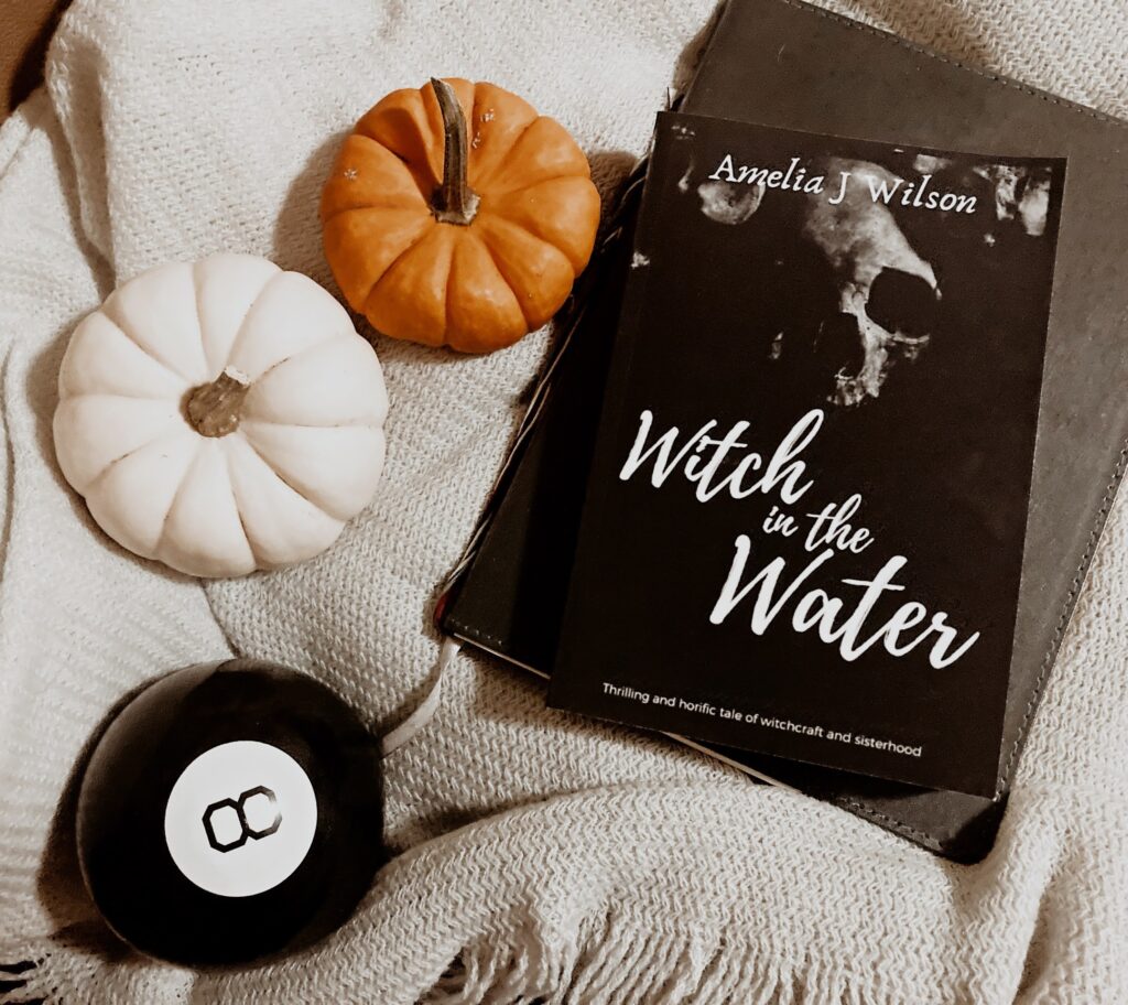 witch in the water book on blanket with pumpkins
