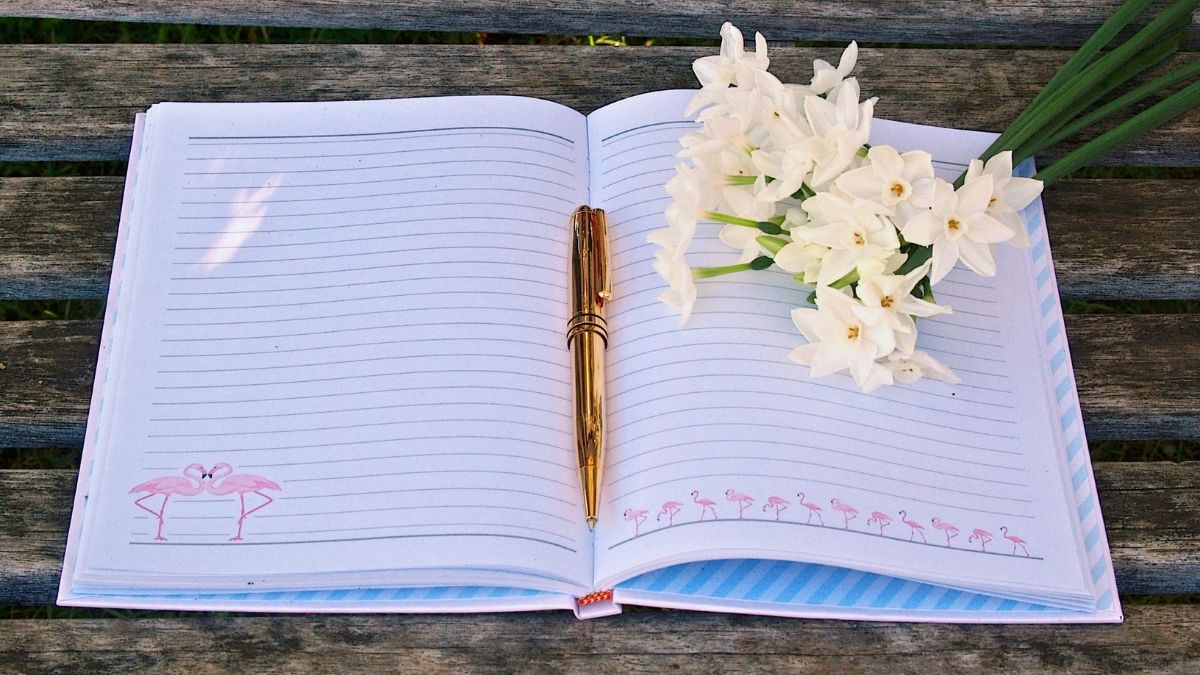 open journal with flowers and pen