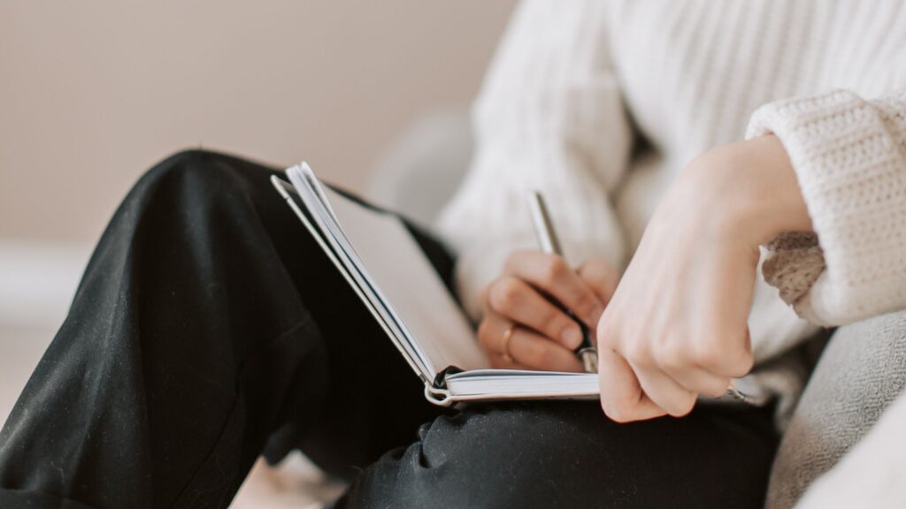 person journaling in chair
