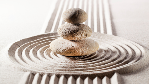 rocks balanced on each other with zen sand formation