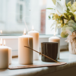 incense and candles with a plant on a shelf by a window